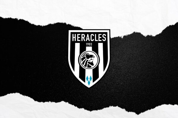 Deze afbeelding toont het logo van Heracles Almelo, een Nederlandse voetbalclub opgericht in 1903. Het logo heeft een zwart-wit gestreept schild met het hoofd van de Griekse halfgod Herakles, een verwijzing naar de naam van de club.